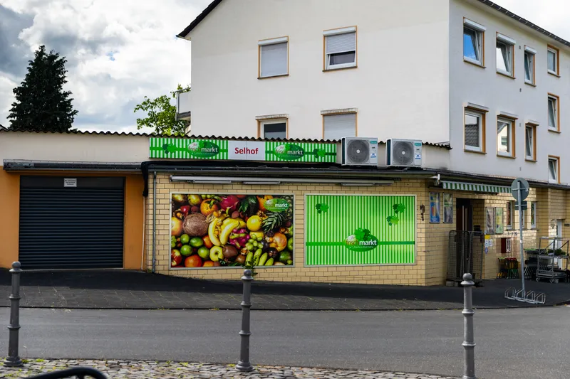 Außenansicht von Ihr Frischmarkt Selhof in Bad Honnef mit Marktschild und frischem Obst und Gemüse im Schaufenster